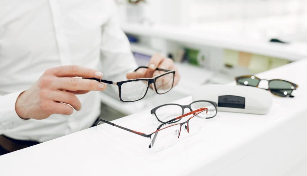 un opticien manipule des lunettes de vue